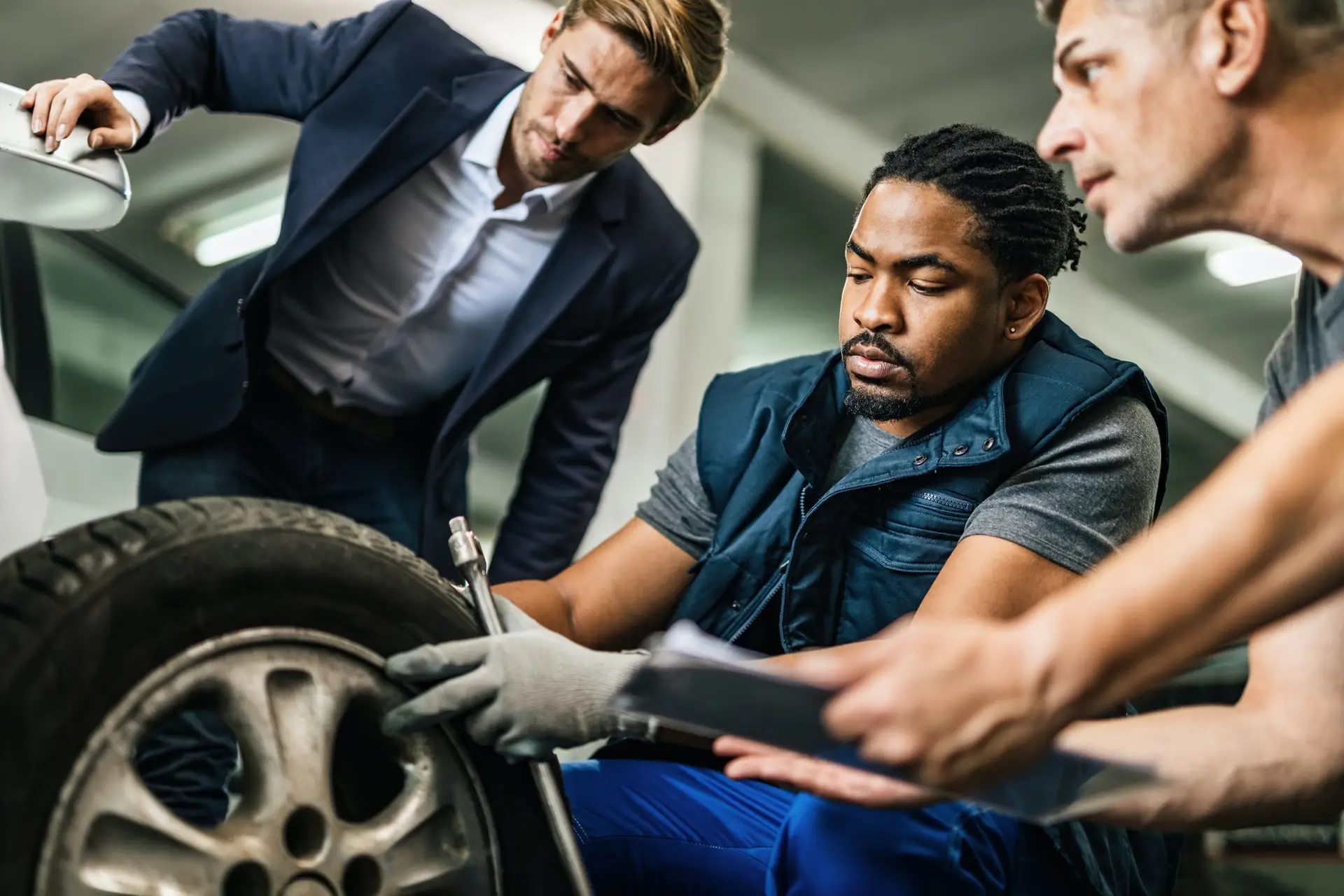 How To Find An Emergency Tire Service Auto mechanics repairing tire of customer's car at repair workshop.