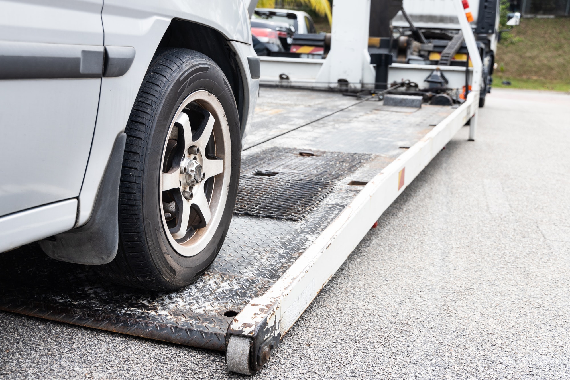 How do you find the cost of towing a car?Cable attached to broken down car being pulled onto tow truck