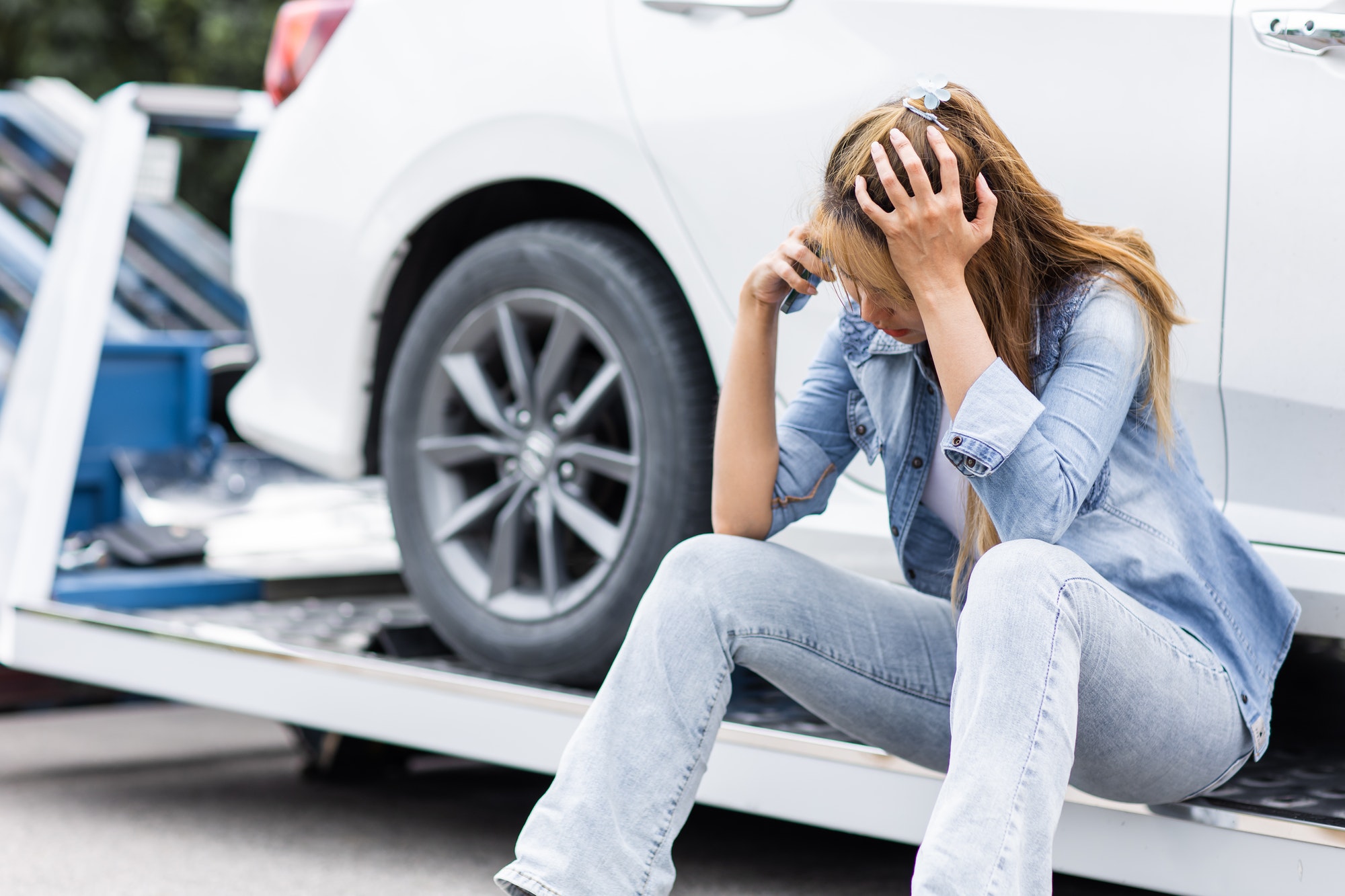 Do Towed Vehicle Locators Work? woman calling roadside car broken for need help while towing service assistance moving her car out