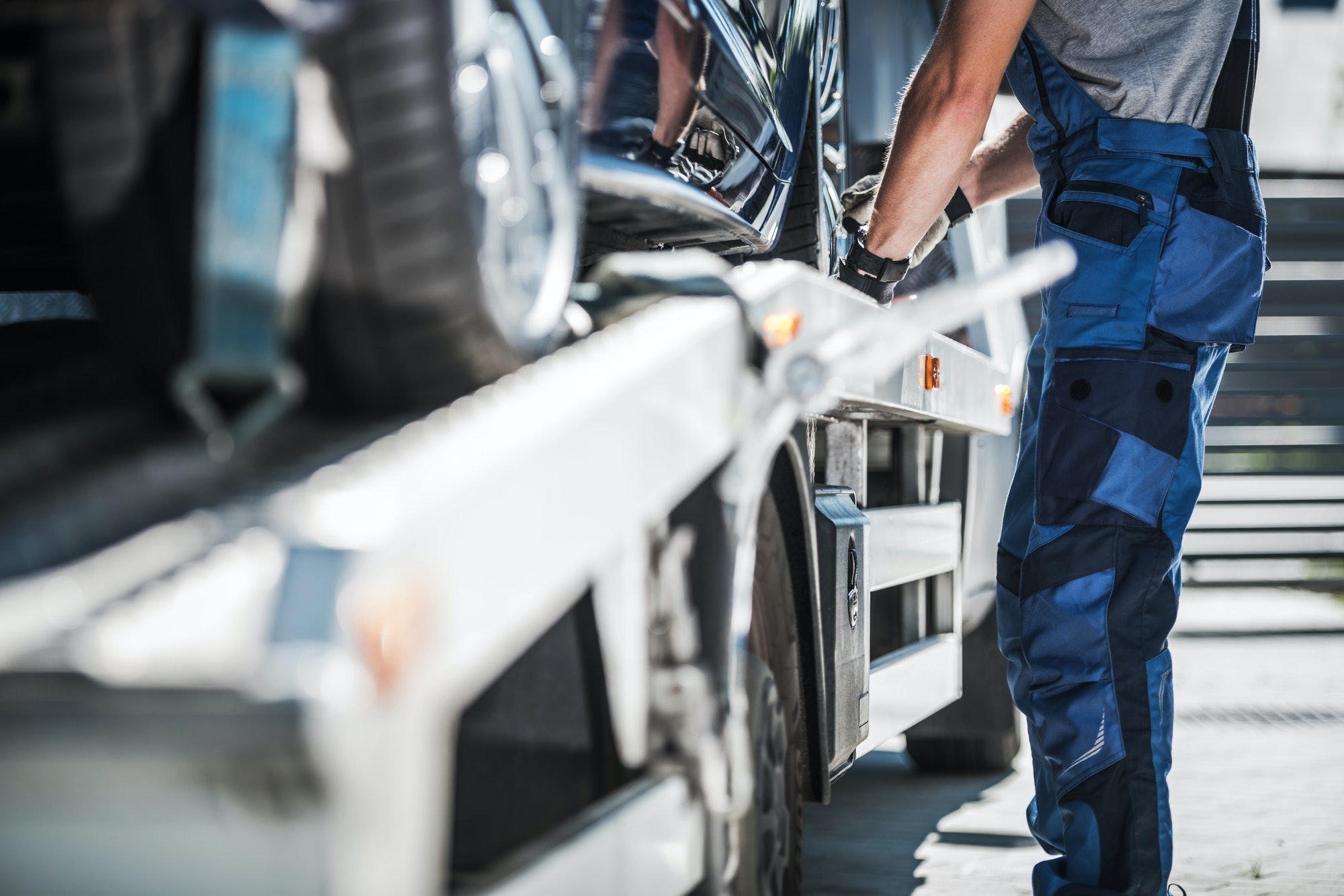 How Long Does It Take to Charge a Car Battery- Know Your Car Battery Worker Securing Car on a Towing Truck